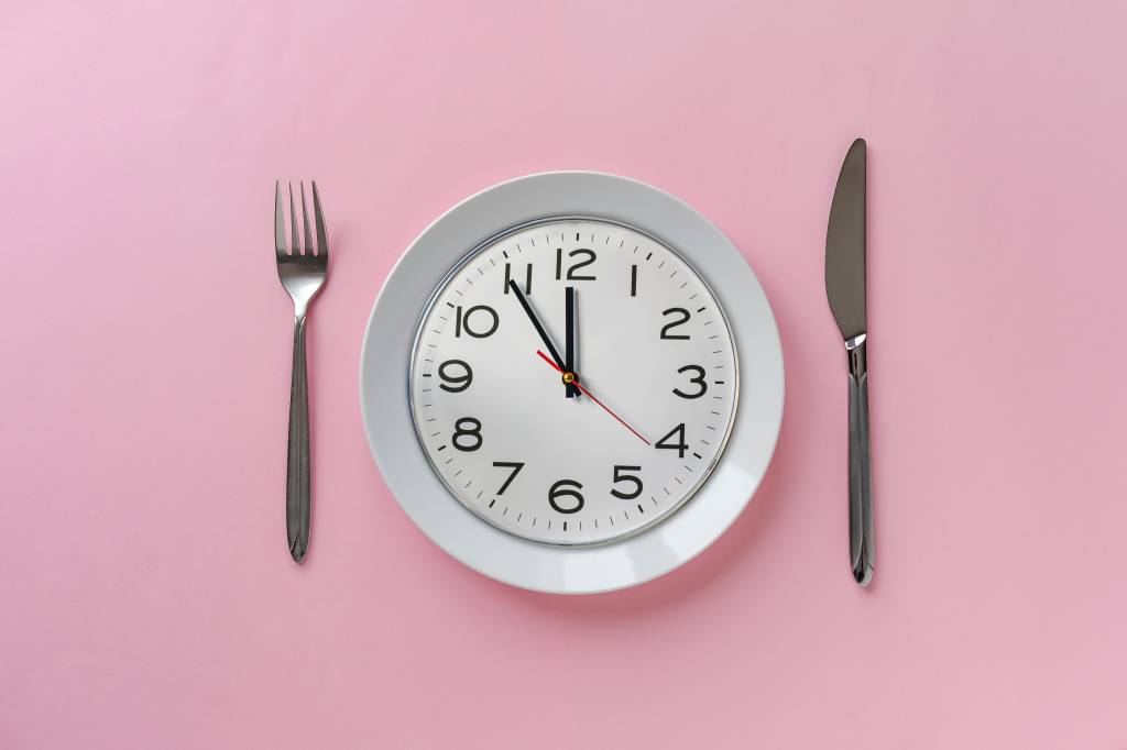 Pink table setting with clock on a plate