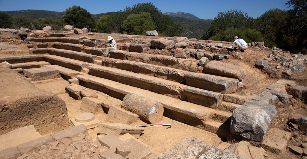 Arquitetos Kübra Sağlam e Gizem Seymen trabalhando em desenhos arquitetônicos de Bouleuterion, vista para noroeste. Crédito da foto: Notion Archaeological Project, University of Michigan