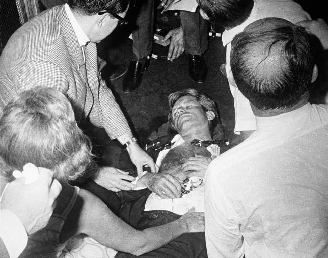 Clutching his rosary beads, Senator Robert F. Kennedy lies wounded on the floor of the Ambassador Hotel, after being shot by an assailant, following his victory speech in the California primary election. Kennedy's wife Ethel is at lower left