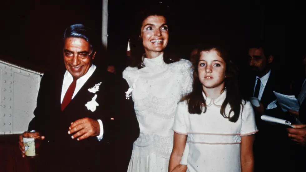 Jackie O, com Aristóteles Onassis e a filha Caroline Kennedy - vestido de noiva entrou para a história