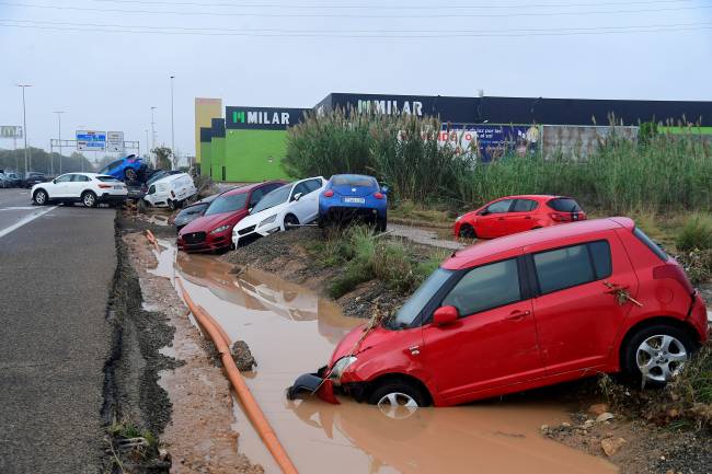 Cars piled due to mudslide following floods are pictured in Picanya, near Valencia, eastern Spain, on October 30, 2024. Floods triggered by torrential rains in Spain's eastern Valencia region has left 51 people dead, rescue services said on October 30. (Photo by Jose Jordan / AFP)