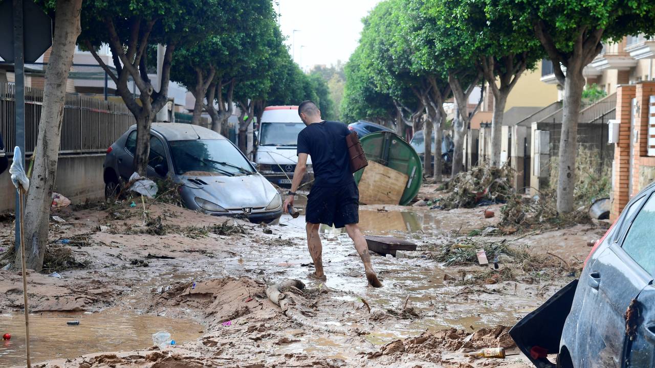 A man walks in a street covered in mud in a flooded area in Picanya, near Valencia, eastern Spain, on October 30, 2024. Floods triggered by torrential rains in Spain's eastern Valencia region has left 51 people dead, rescue services said on October 30. (Photo by Jose Jordan / AFP)