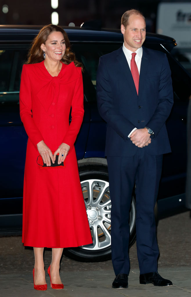O vestido casaco vermelho de Catherine Walker, al&eacute;m de evocar o Natal, tamb&eacute;m evoca a moda brit&acirc;nica. Para arrematar a produ&ccedil;&atilde;o, Kate escolheu uma clutch preta Miu Miu e sapatos Gianvito Rossi