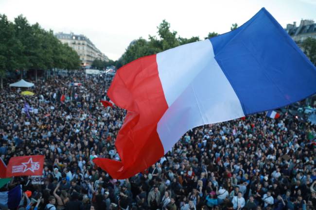 Left-wing alliance leads in French elections: Exit polls PARIS, FRANCE - JULY 07: People, holding flags and banners, gather at the Republique Square following the second round results of France's legislative election in Paris, France on July 07, 2024. France's left-wing New Popular Front alliance leads in Sunday's snap parliamentary elections, seemingly halting the rise of far-right, polls said. The NFP could win 180 to 215 seats in the parliament's lower chamber, the National Assembly, according to projections based on the surveying company Ifop's estimations. The centrist alliance, Together for the Republic, backed by President Emmanuel Macron ranked second with 150 to 180 seats, while Marine Le Pen's far-right National Rally (RN), which celebrated its victory in the first round, will get 120 to 150 seats. (Photo by Mohamad Salaheldin Abdelg Alsayed/Anadolu via Getty Images)