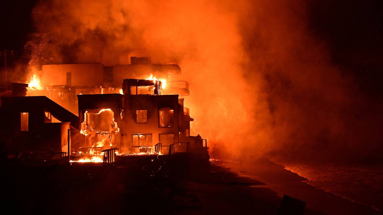 Uma casa de praia é engolida pelas chamas enquanto o incêndio Palisades queima ao longo da Pacific Coast Highway em Malibu, Califórnia, em 8 de janeiro de 2025.
