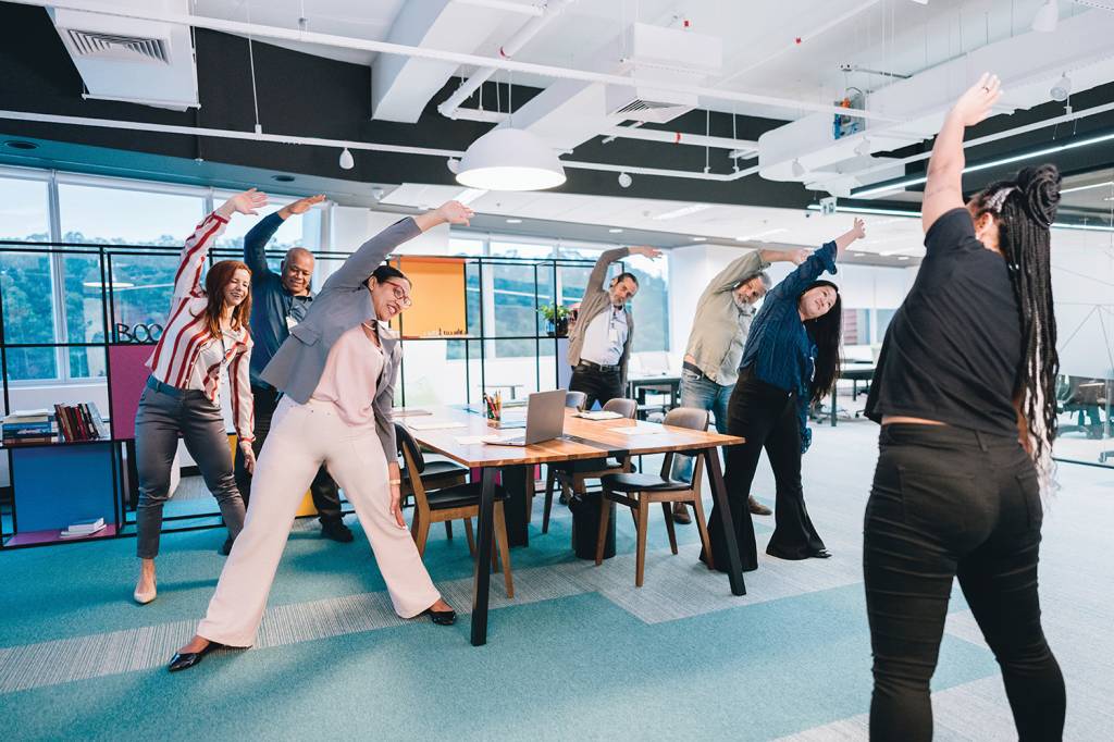 Business people on an active break at the office INTERVALO - Sessões curtas de exercícios: pequenas séries de cinco minutos já podem fazer diferença