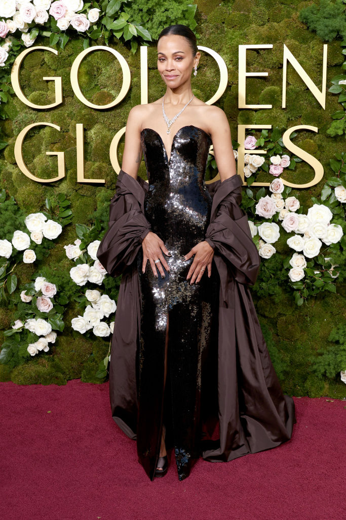 Zoe Saldana chegou arrasadora em um vestido preto de malha de cristal da Saint Laurent e joias Cartier