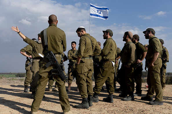Soldados israelenses em volta da bandeira de Israel. 05/12/2024