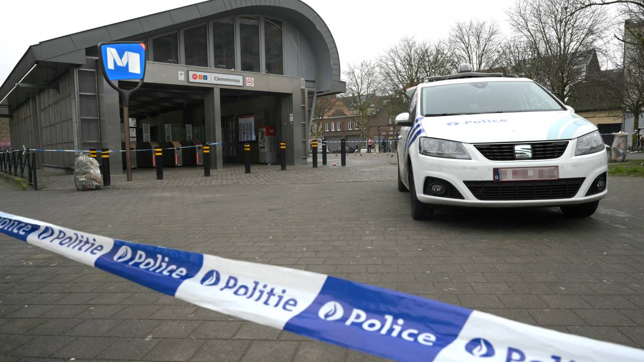 Police tape secures the area and a police car is parked outside the Clemenceau metro station following a shooting, in Brussels on February 5, 2025. Brussels police searched for at least two gunmen on February 5, after shots were fired oustide a metro station, authorities said. A police spokeswoman said shots were heard at around 6.00am (0500 GMT) outside a station close to the city centre. Surveillance footage obtained by broadcaster RTBF showed two masked people carrying automatic rifles outside the metro, with at least one letting off repeated shots. (Photo by NICOLAS TUCAT / AFP)