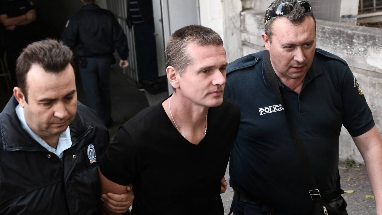 O russo Alexander Vinnik (C) é escoltado por policiais ao chegar a um tribunal em Tessalônica em 4 de outubro de 2017