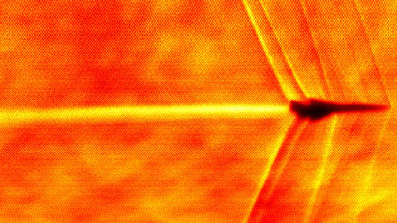 Fotografia Schlieren, que permite visualizar variações na densidade do ar, tornando as ondas de choque visíveis, do momento em que o XB-1 atinge o Mach 1 -