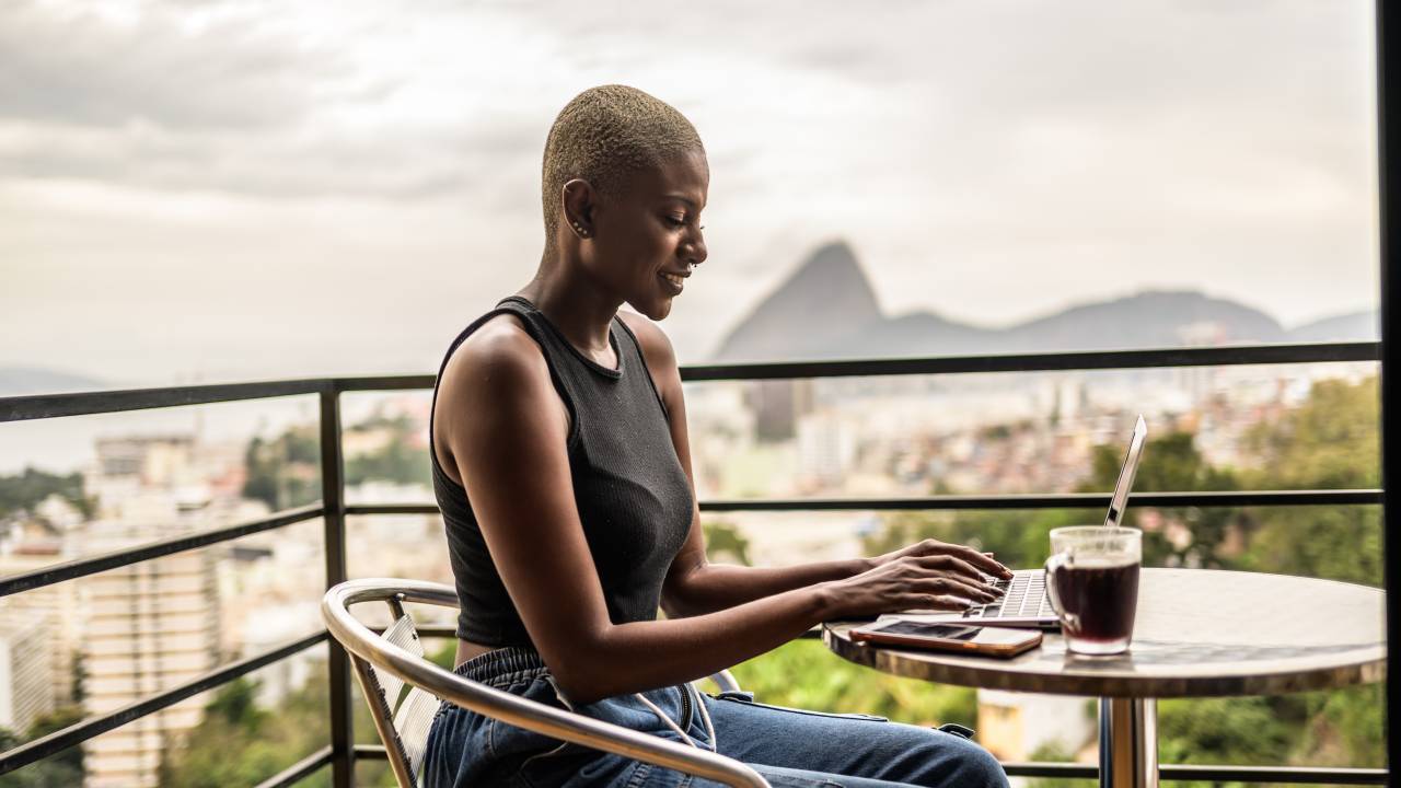 Uma viajante trabalha com vista para a paisagem do Rio