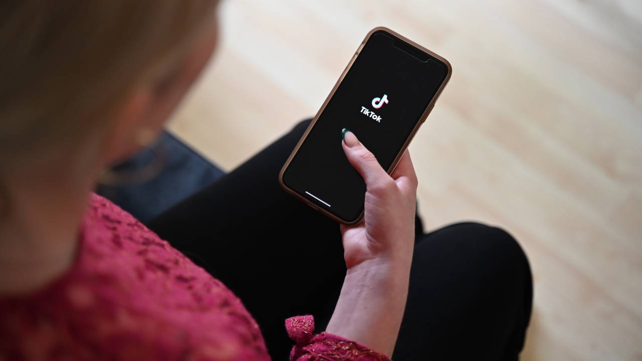 A woman opens Tiktok on her smartphone.