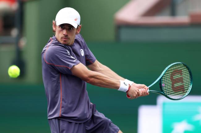 INDIAN WELLS, CALIFORNIA - MARCH 12: Alex de Minaur of Australia plays a backhand against Francisco Cerundolo of Argentina in their fourth round match during the BNP Paribas Open at Indian Wells Tennis Garden on March 12, 2025 in Indian Wells, California. (Photo by Clive Brunskill/Getty Images)