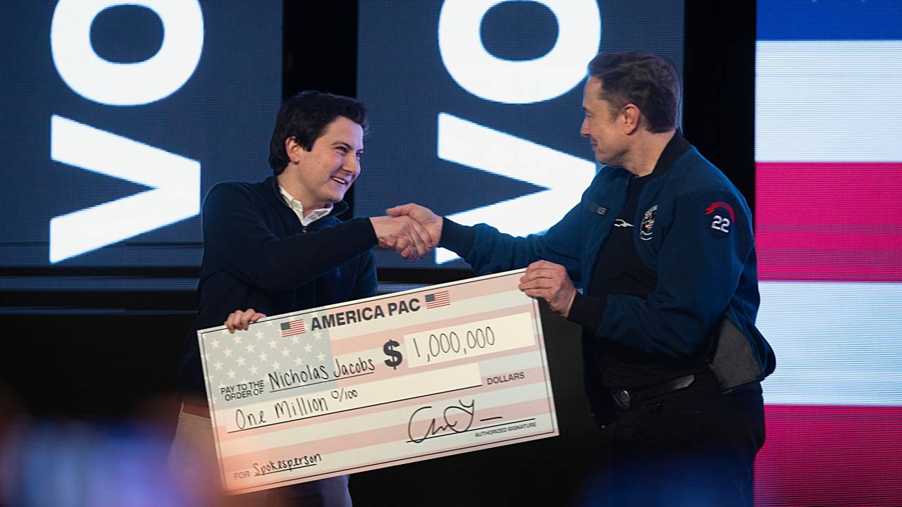Elon Musk dá US$ 1.000.000 a um eleitor de Wisconsin, Nicholas Jacobs, durante uma reunião municipal no Centro de Convenções de KI, em Green Bay. 30/03/2025