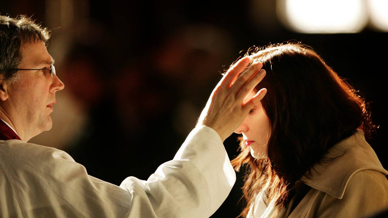 LONDON - FEBRUARY 21: A worshipper receives a cross of ashes painted on her forehead from a priest during Ash Wednesday Mass at Westminster Cathedral on February 21, 2007 in London. During the traditional Catholicism Ash Wednesday Mass, the priest places ashes on the middle of people's forehead as an ancient symbol of repentance. (Photo by Peter Macdiarmid/Getty Images)