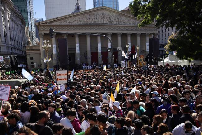 Faithful attend a mass to bid farewell to Pope Francis in front of the Buenos Aires Cathedral on April 26, 2025. With songs, candles, flags, and prayers, Buenos Aires mourners marked the burial of pontiff and native son Pope Francis on Saturday. As the 88-year-old was being laid to rest an ocean away in Rome, thousands gathered by Buenos Aires' cathedral for dawn vigils and a mass of remembrance. (Photo by Emiliano Lasalvia / AFP)