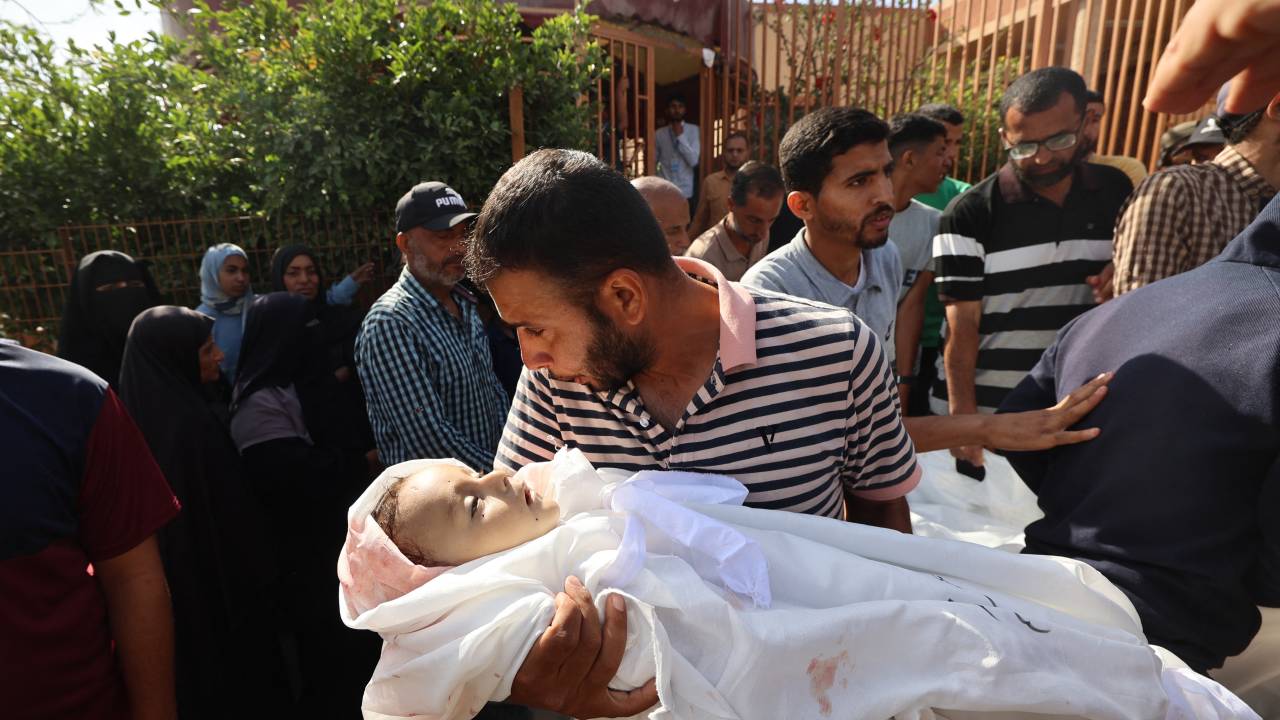 Homem segura corpo de bebê que foi vítima de um ataque israelense em Khan Yunis, no sul de Gaza. 14/05/2025