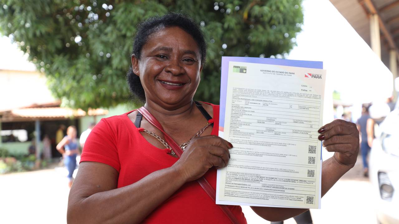 Mulher segura sua documentação e posa para foto