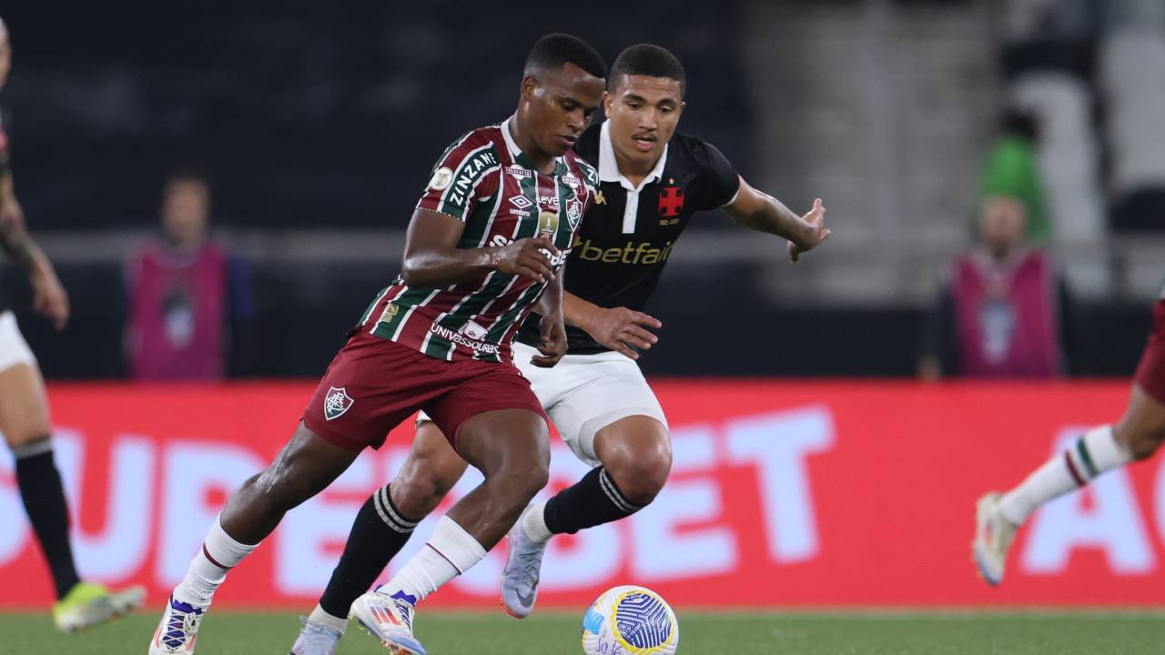 RIO DE JANEIRO, BRAZIL - AUGUST 10: John Arias of Fluminense drives the ball against Mateus Carvalho of Vasco da Gama during a Brasileirao 2024 match between Vasco and Fluminense at Estadio Olimpico Nilton Santos on August 10, 2024 in Rio de Janeiro, Brazil. (Photo by Lucas Figueiredo/Getty Images)