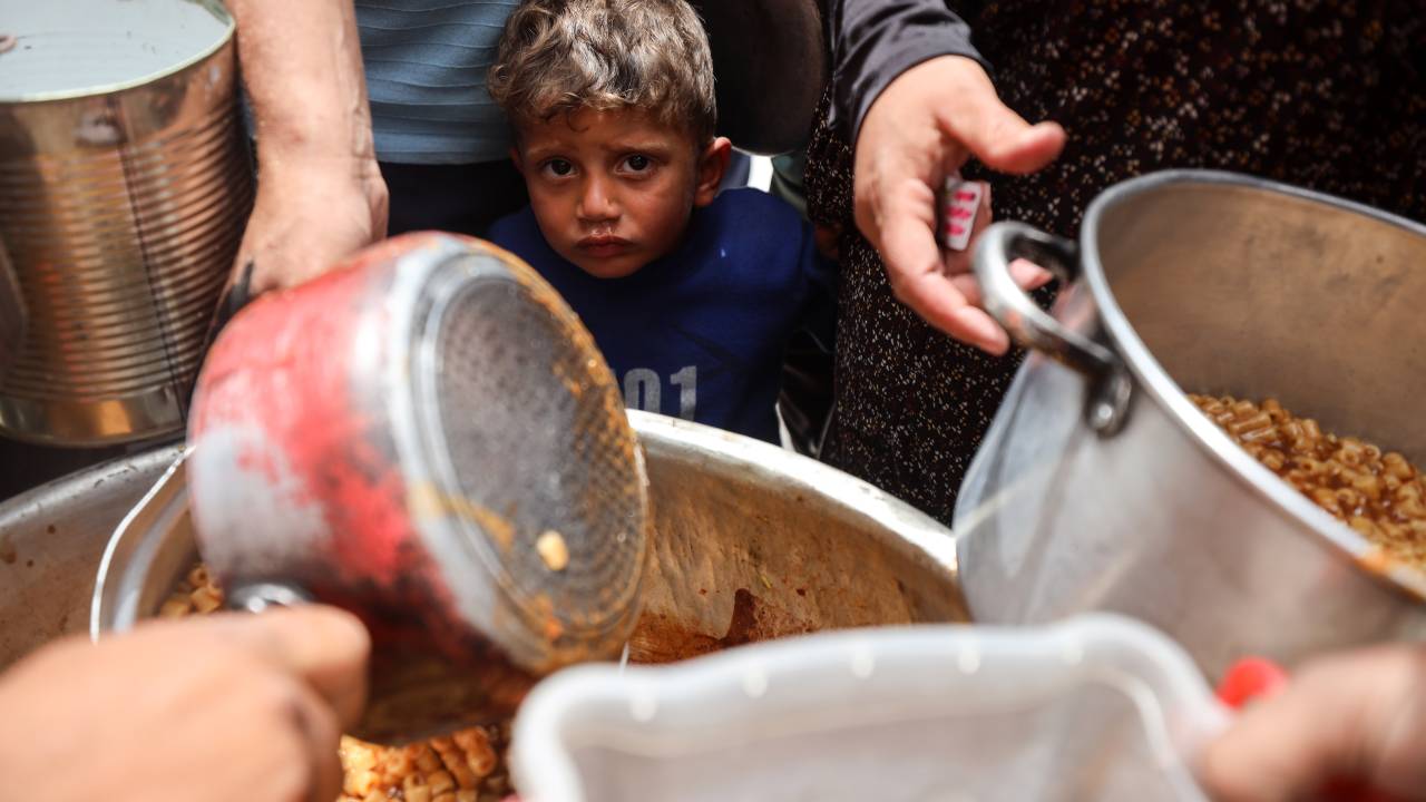 Palestinos deslocados fazem fila para receber uma porção de comida de uma cozinha de caridade na Cidade de Gaza. 30/04/2025