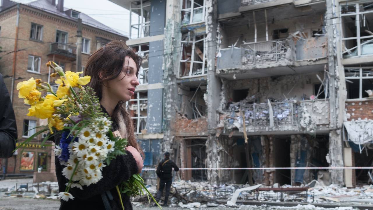 Uma mulher passa por um prédio residencial severamente danificado por um ataque de drone russo em Kiev, na Ucrânia. 25/05/2025