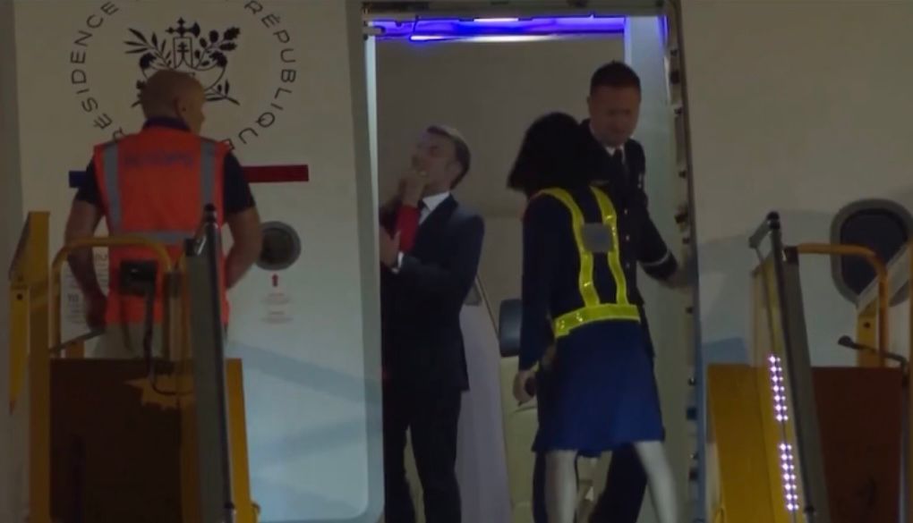 A primeira-dama da França, Brigitte Macron, empurrando bruscamente o rosto do presidente Emmanuel Macron.