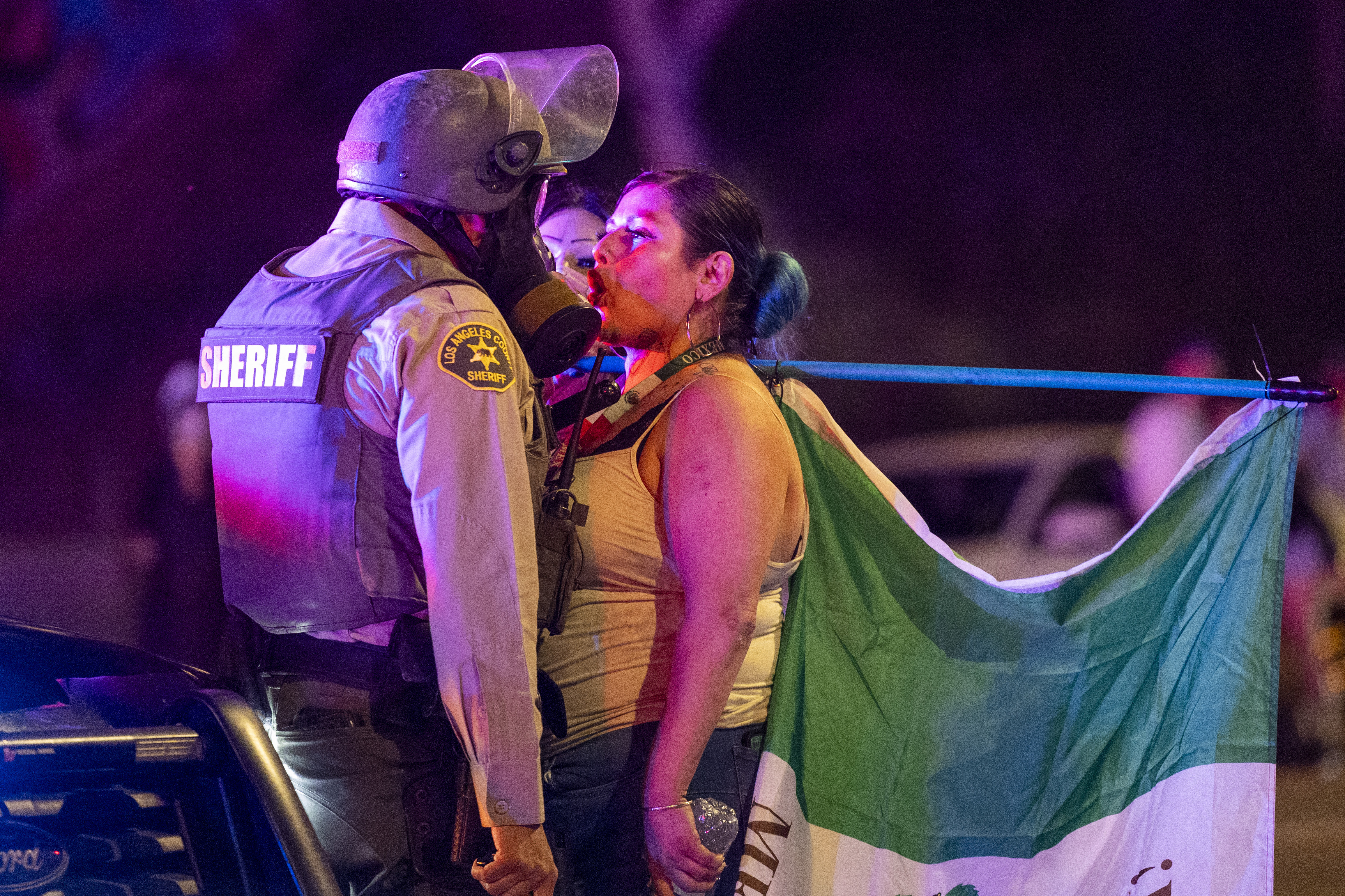 A protester faces off with a Sheriff deputy amid clashes with law enforcement in the streets surrounding the federal building during a protest following federal immigration operations in Los Angeles, California, on June 8, 2025. Demonstrators torched cars and scuffled with security forces in Los Angeles on June 8, as police kept protestors away from the National Guard troops President Donald Trump sent to the streets of the second biggest US city. (Photo by RINGO CHIU / AFP)