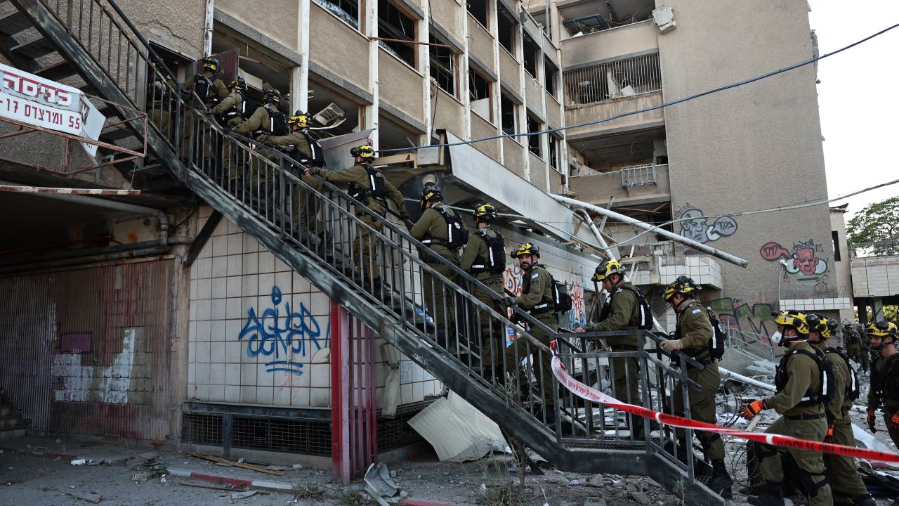 Israeli first responders enter a building that was hit by an Iranian strike in Haifa on June 20, 2025, amid the ongoing fire exchange between Israel and Iran. (Photo by Fadel SENNA / AFP)