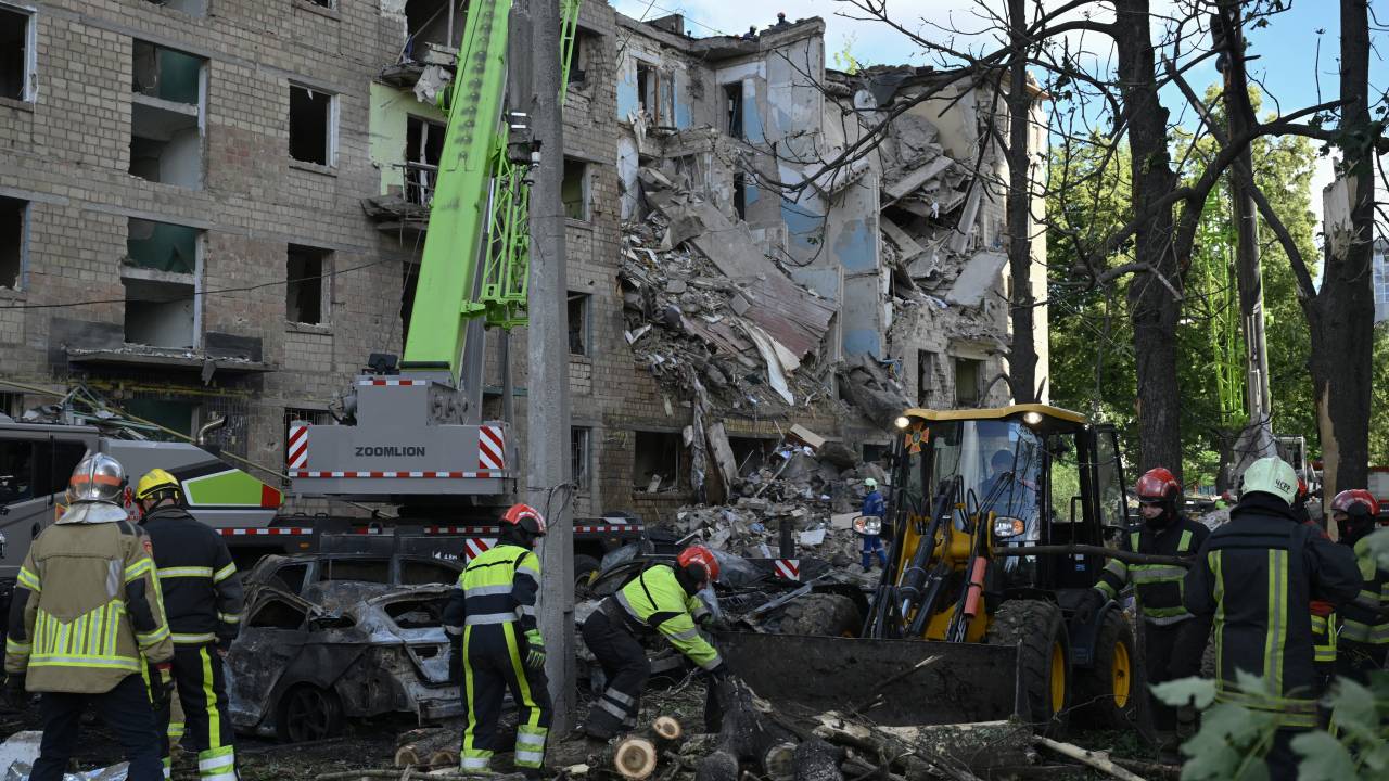 Ukrainian rescuers clear debris as they conduct a search operation at the site of a residential building, heavily damaged following a strike in Kyiv on June 23, 2025, amid the Russian invasion of Ukraine. Russia fired 352 drones and 16 missiles at Ukraine overnight, killing at least seven people in the capital Kyiv and its suburbs, Ukrainian President Volodymyr Zelensky said on June 23, 2025. (Photo by Genya SAVILOV / AFP)