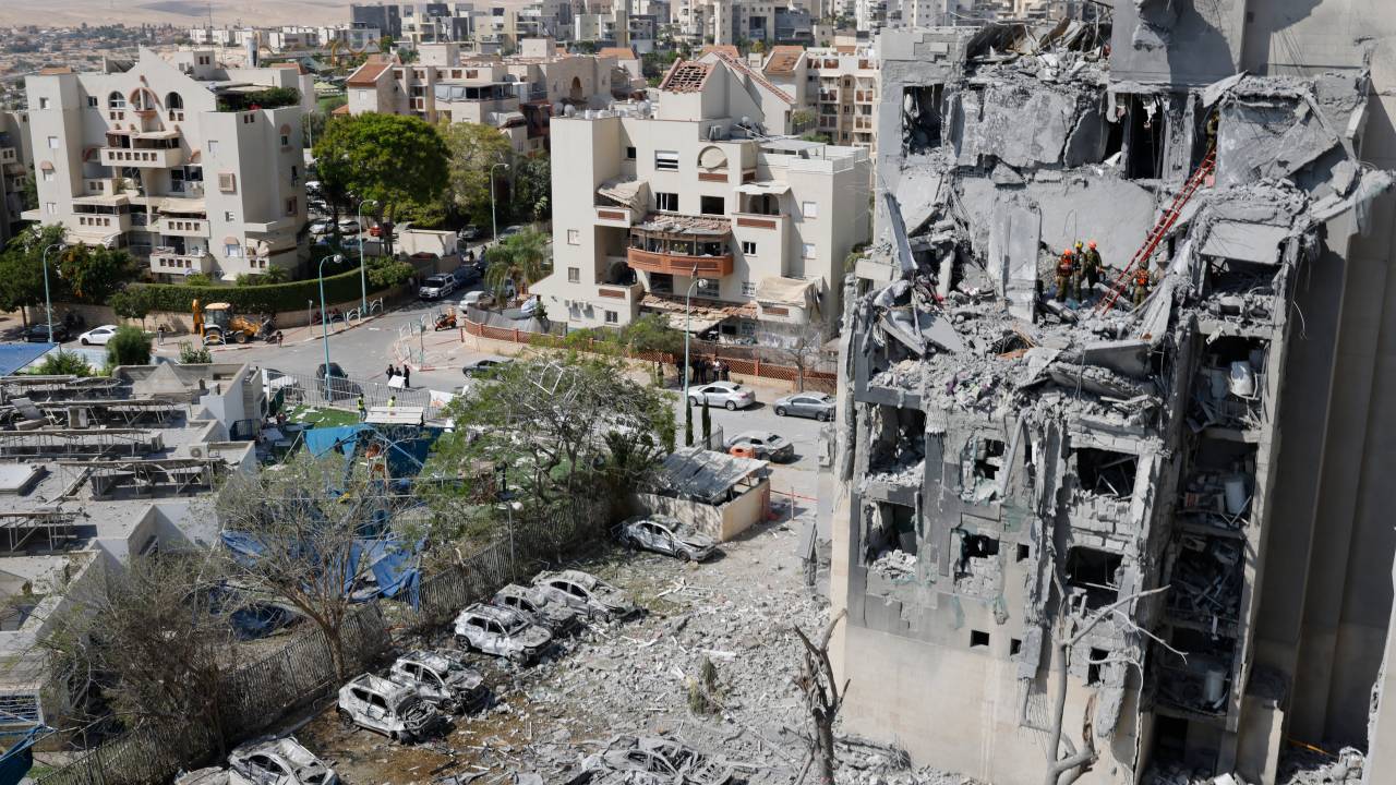 Emergency workers check the damage caused to a building from an Iranian missile strike in Beersheba in southern Israel on June 24, 2025. Israel said on June 24 it had agreed to US President Donald Trump's proposal for a ceasefire with Iran, on the 12th day of war between the foes. (Photo by John Wessels / AFP)