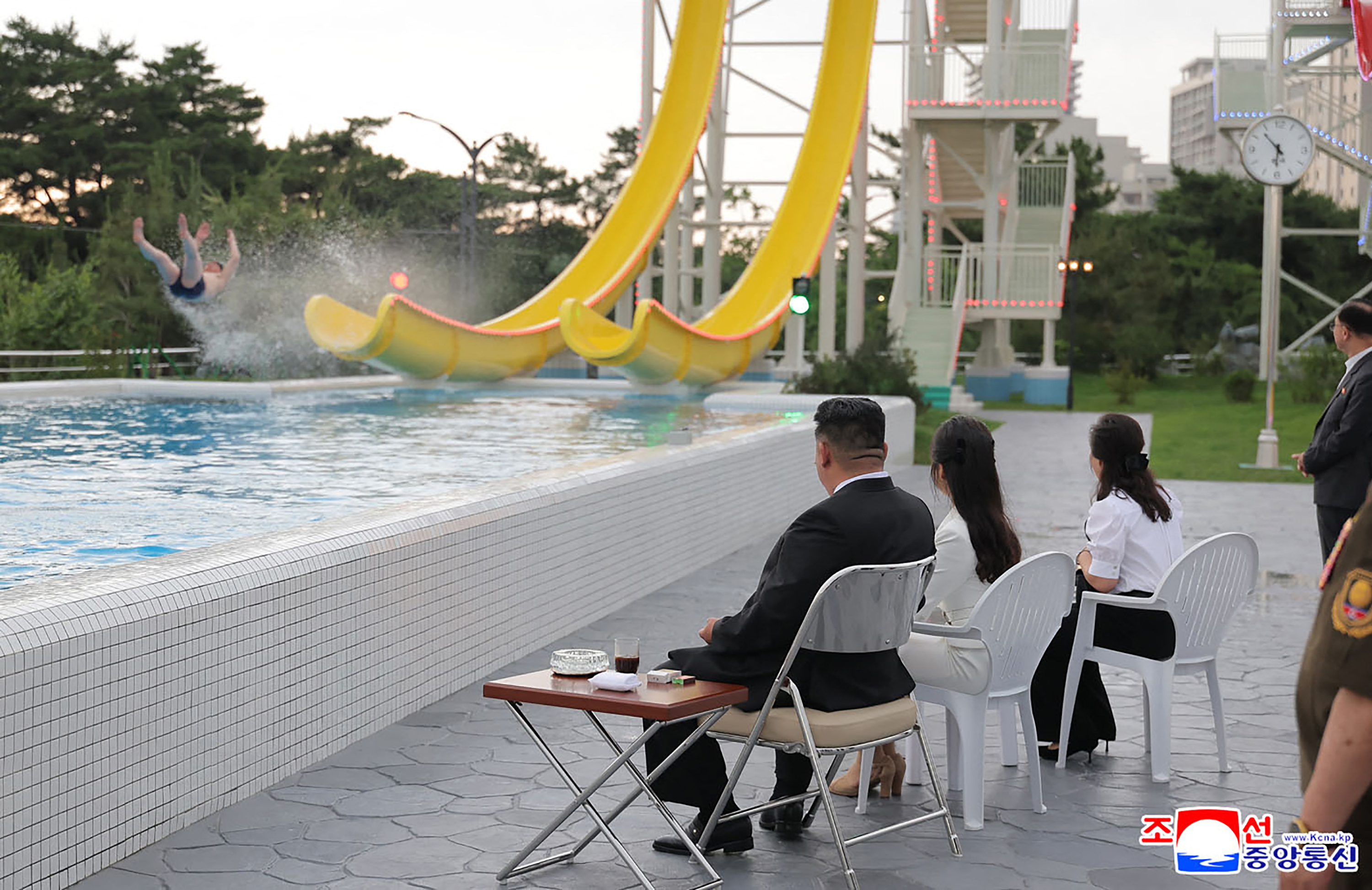 O líder norte-coreano, Kim Jong Un (centro, esq.), sua filha Kim Ju Ae (terceira esq.) e sua esposa Ri Sol Ju (esq.) assistem turistas em escorrega d'água. 26/06/2025