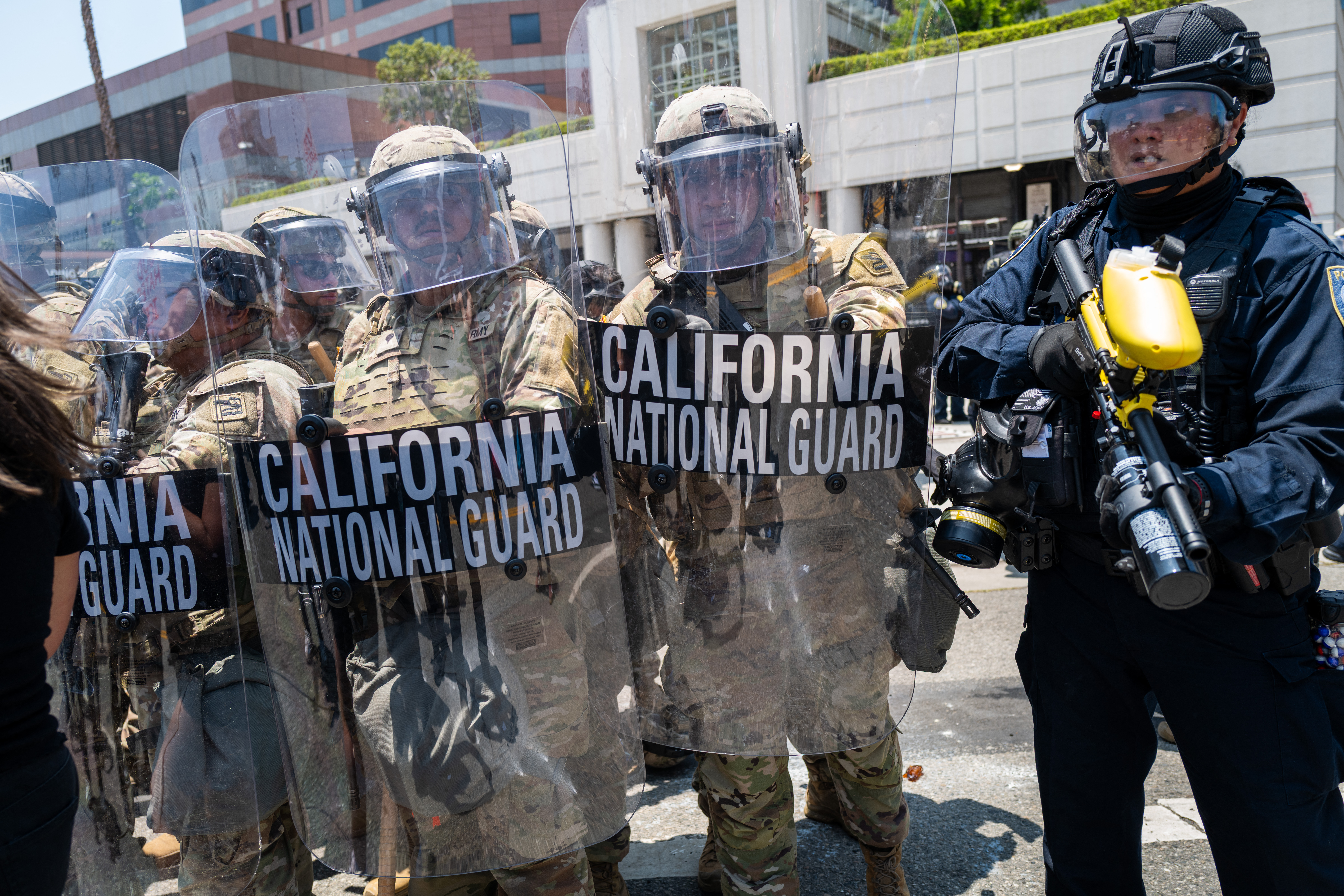 LOS ANGELES, CALIFORNIA - JUNE 08: LAPD officers and National Guard soldiers stand on patrol as demonstrators protest outside a downtown jail in Los Angeles following two days of clashes with police during a series of immigration raids on June 08, 2025 in Los Angeles, California. Tensions in the city remain high after the Trump administration called in the National Guard against the wishes of city leaders. Spencer Platt/Getty Images/AFP (Photo by SPENCER PLATT / GETTY IMAGES NORTH AMERICA / Getty Images via AFP)