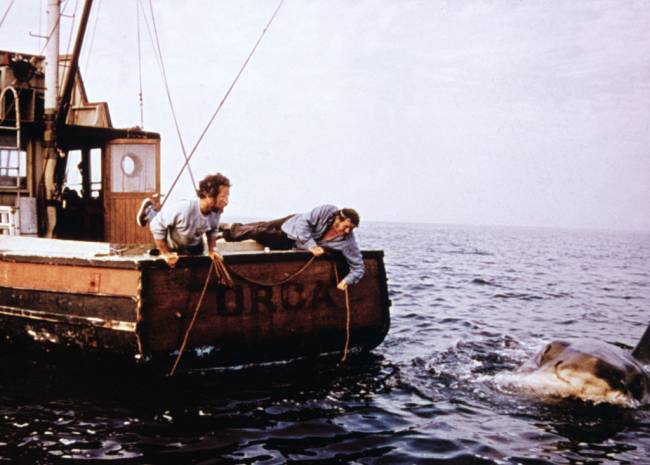 Dreyfuss and Shaw Fishing in ‘Jaws,’ 1975. Richard Dreyfuss e Robert Shaw a bordo do barco Orca, em perseguição ao tubarão branco gigante, em cena de Tubarão (1975), dirigido por Steven Spielberg
