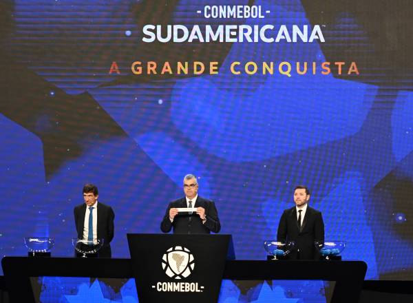 LUQUE, PARAGUAY - MARCH 17: Fred Nantes, Director of Competitions of CONMEBOL, holds the Sportivo Luqueño slip next to Gustavo Costas, Head Coach of Racing Club (L) and José Rojas, former player, (R) during the Copa CONMEBOL Sudamericana 2025 draw on March 17, 2025 in Luque, Paraguay. (Photo by Christian Alvarenga/Getty Images)