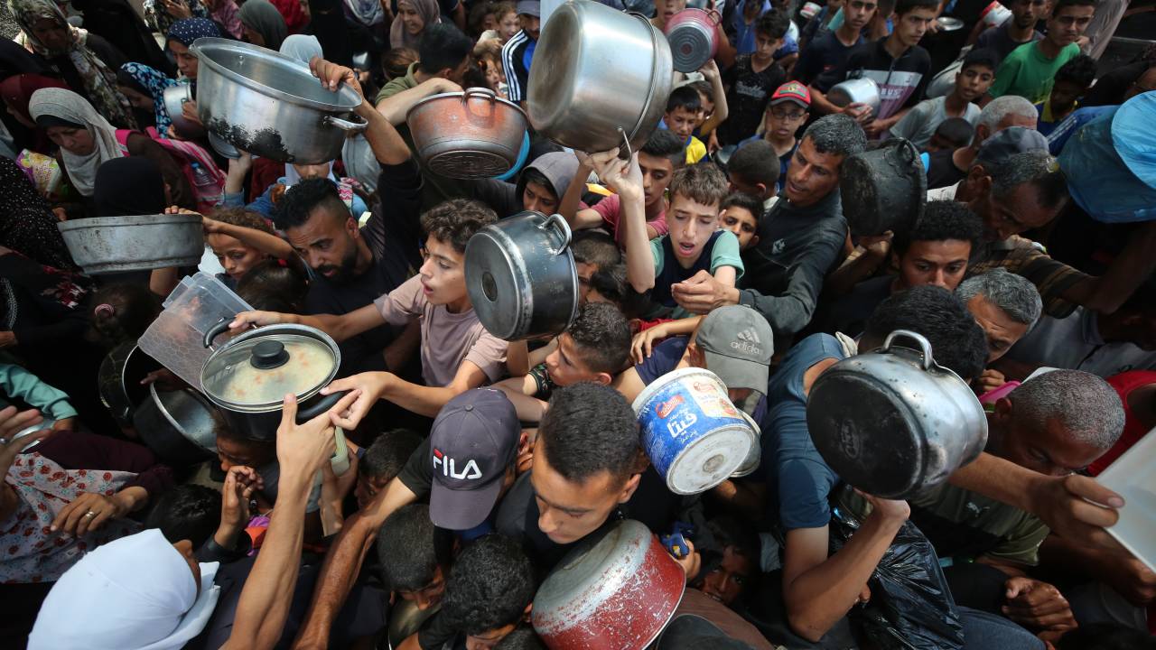 Palestinos deslocados recebem comida de grupo de ajuda humanitária na Cidade de Gaza