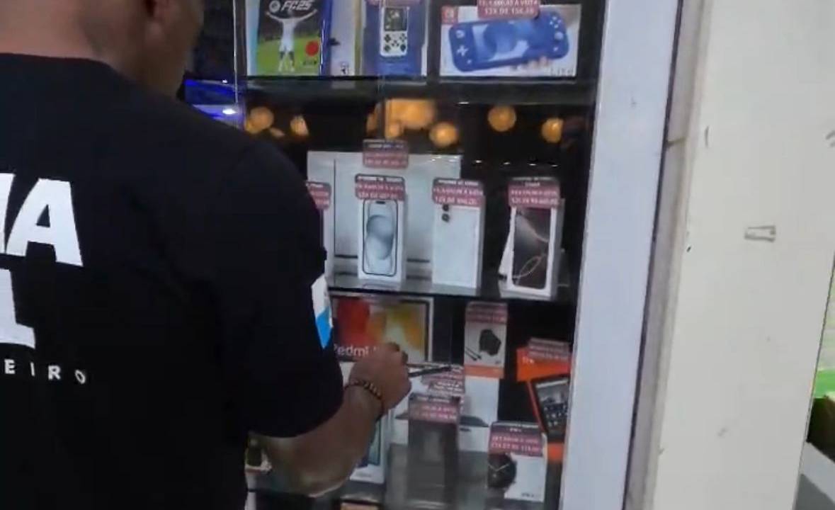 Policial civil em loja de celulares dentro de shopping popular do Rio: ações contra esquema de venda de aparelhos roubados