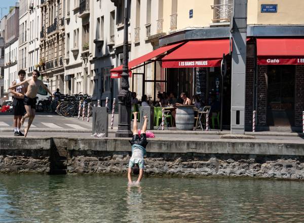 Jovens nadam no canal enquanto uma onda de calor afeta toda a França por vários dias, em Paris, França, em 21 de junho de 2025