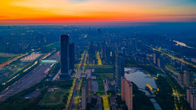 Na parte frontal da imagem está o horizonte da Zona de Desenvolvimento Econômico de Huaqiao, no início da manhã, com o conjunto de arranha-céus de Lujiazui, em Xangai, ao fundo, em setembro de 2025