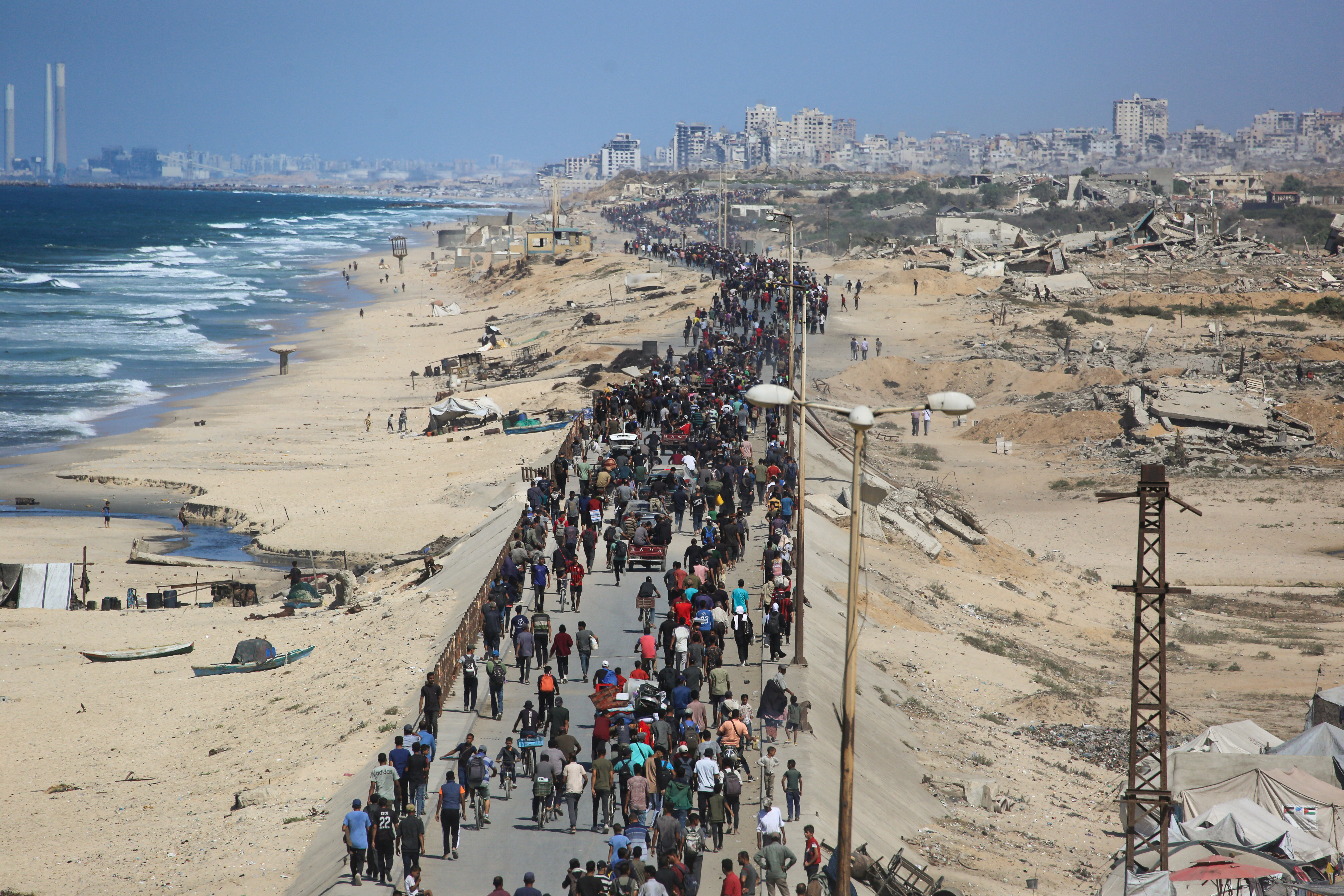 Palestinos seguem pela estrada Al-Rashid em direção à Cidade de Gaza, saindo de Nuseirat, no centro da Faixa de Gaza. 10/10/2025