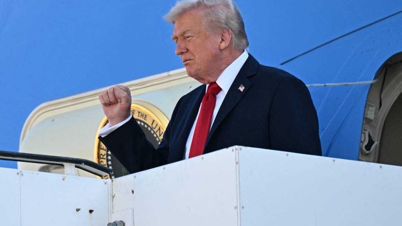 US President Donald Trump gestures as he disembarks from Air Force One upon arrival at Ben Gurion Airport on the outskirts of Lod near Tel Aviv on October 13, 2025, as he travels to Israel and Egypt. Trump is passing through Israel, addressing parliament and meeting with hostage families before heading to Egypt's Sharm El-Sheikh for a major peace summit, where a "document ending the war in the Gaza Strip" is expected to be signed. (Photo by SAUL LOEB / AFP)