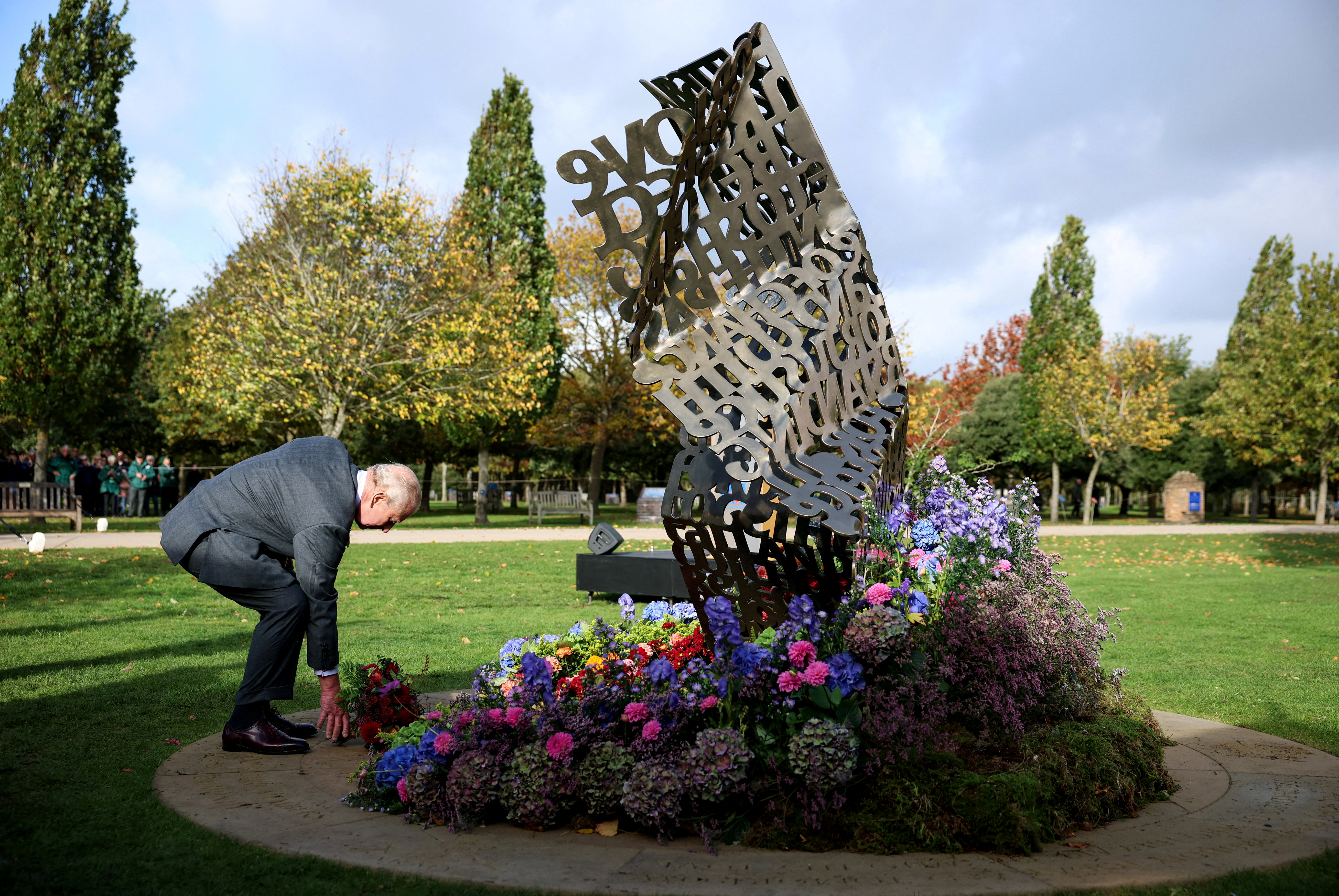 Momento em que o rei Charles III coloca flores no memorial Open Letter em Staffordshire. 27/10/2025