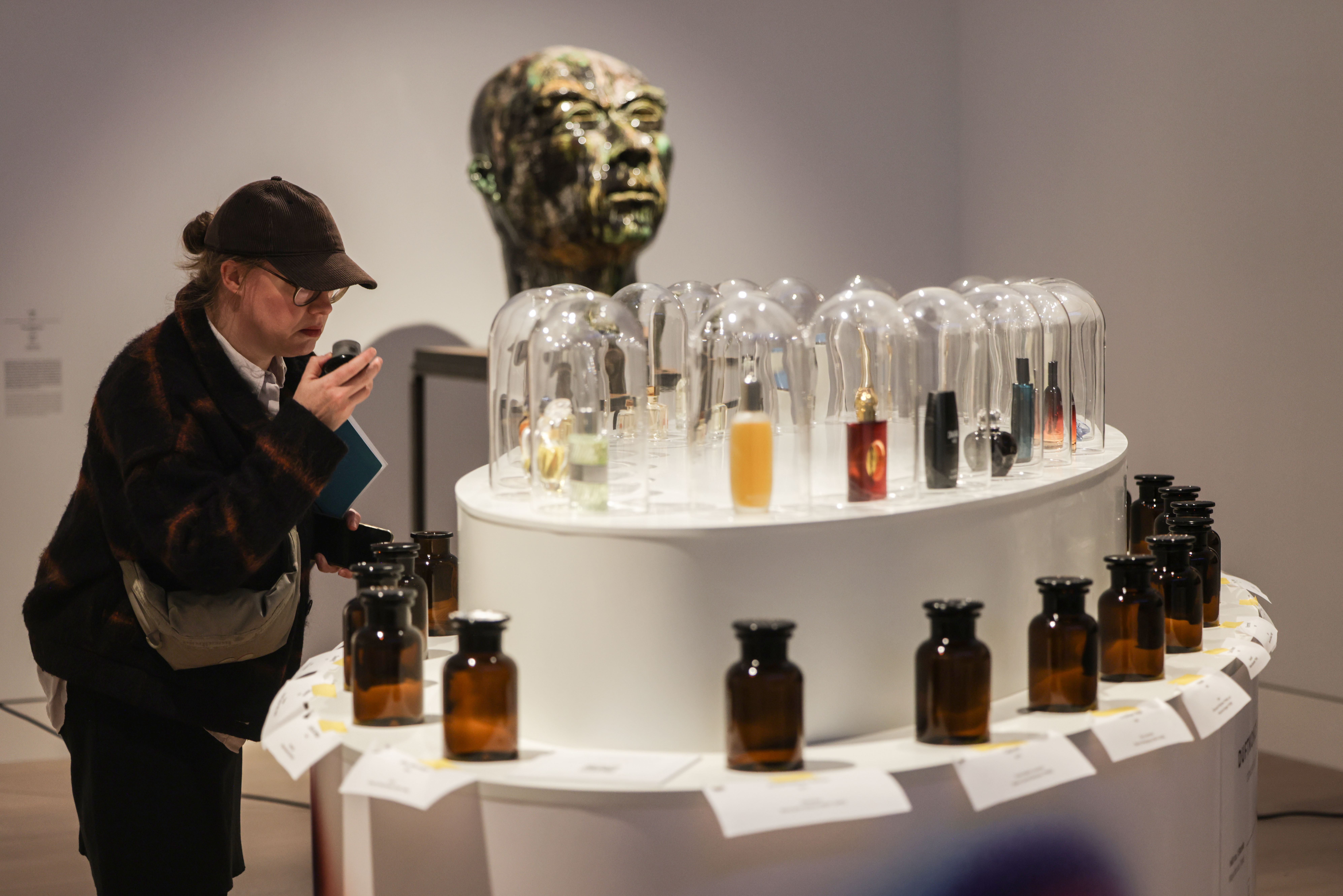 28 October 2025, North Rhine-Westphalia, Duesseldorf: A museum visitor smells perfume fragrances at a scent station. The exhibition