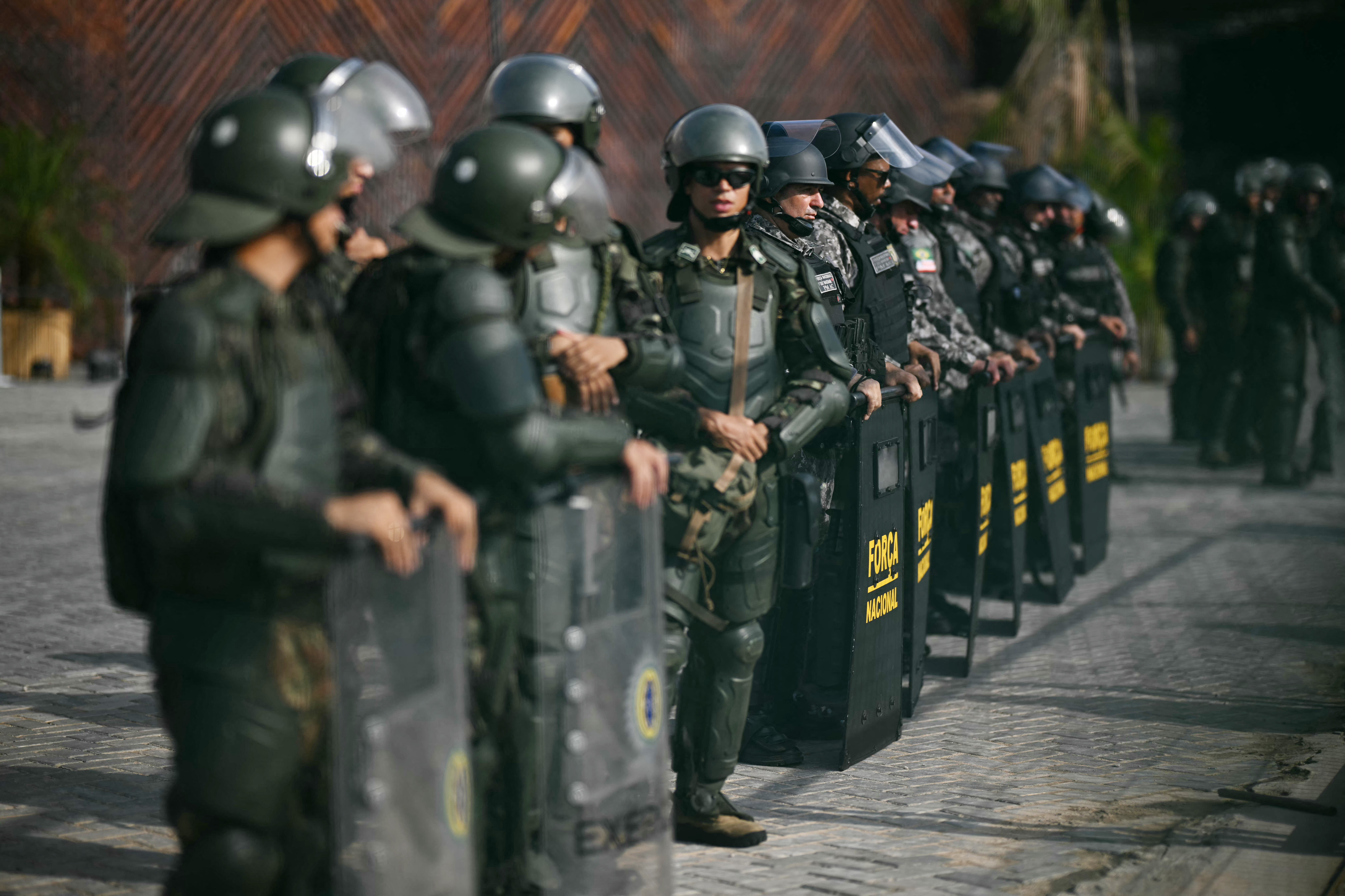 Soldados da For&ccedil;a Nacional fazem a guarda da entrada principal da blue zone da COP30 enquanto membros do povo ind&iacute;gena Munduruku bloqueiam o acesso ao local