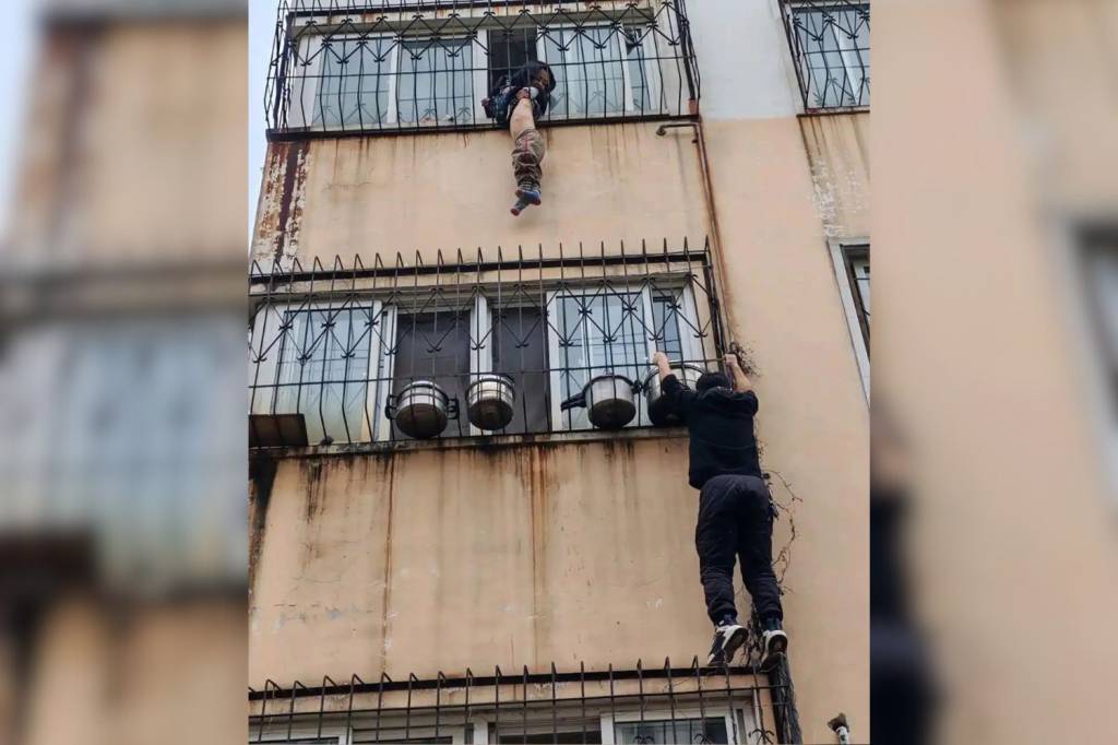 Entregador escala prédio e salva criança pendurada em janela na China