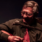 Foto do cantor Julio Reny tocando violão