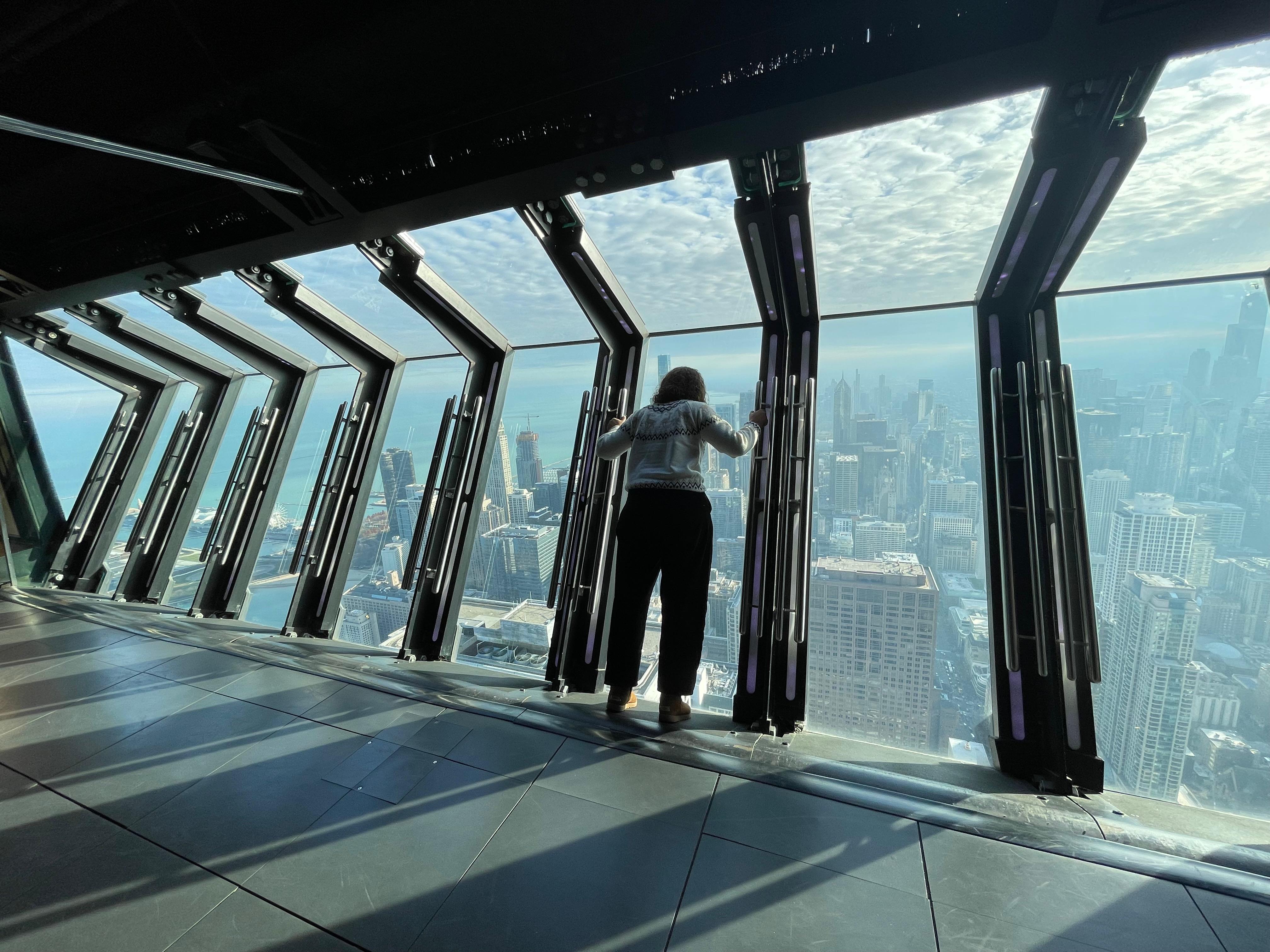 A experiência do Tilt, no 360 Chicago: os visitantes se inclinam para fora do prédio, protegidos por uma plataforma de vidro