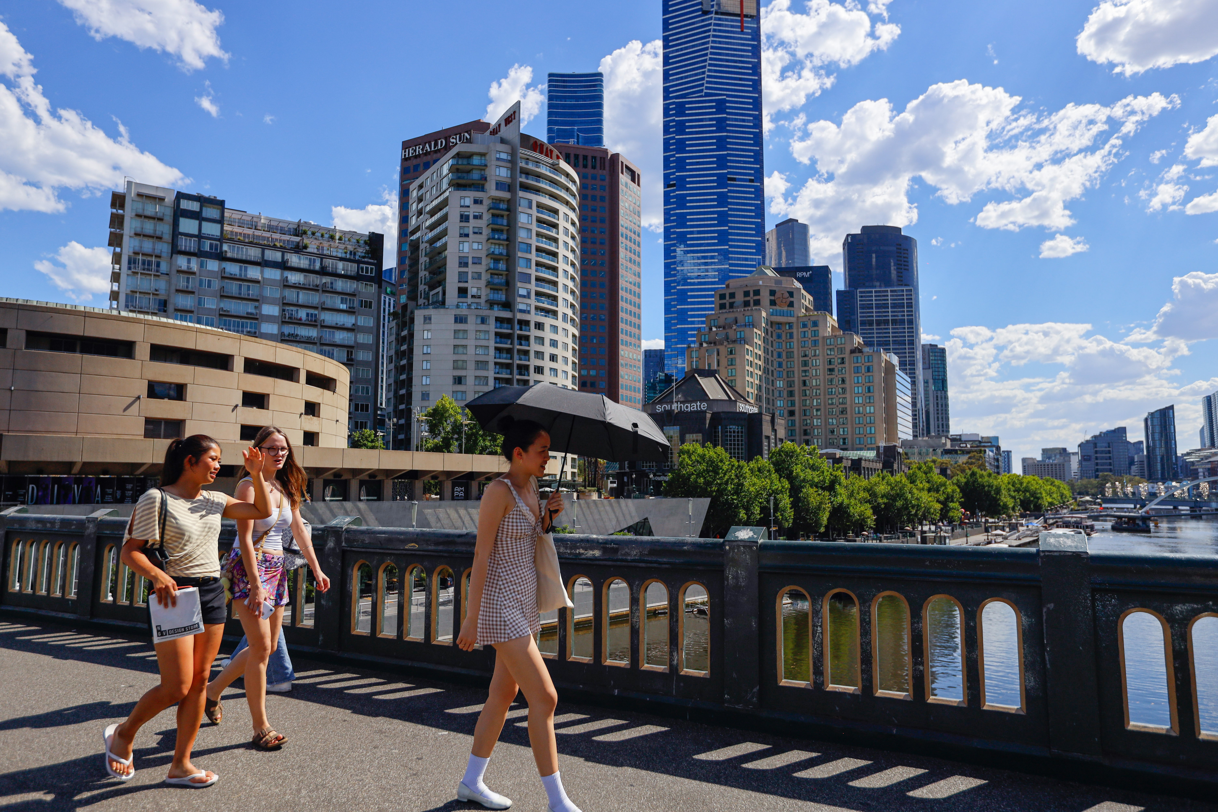 mulher com um guarda-chuva é vista em uma cena geral da cidade durante temperaturas máximas de 42 °C. Melbourne enfrenta uma onda de calor extrema