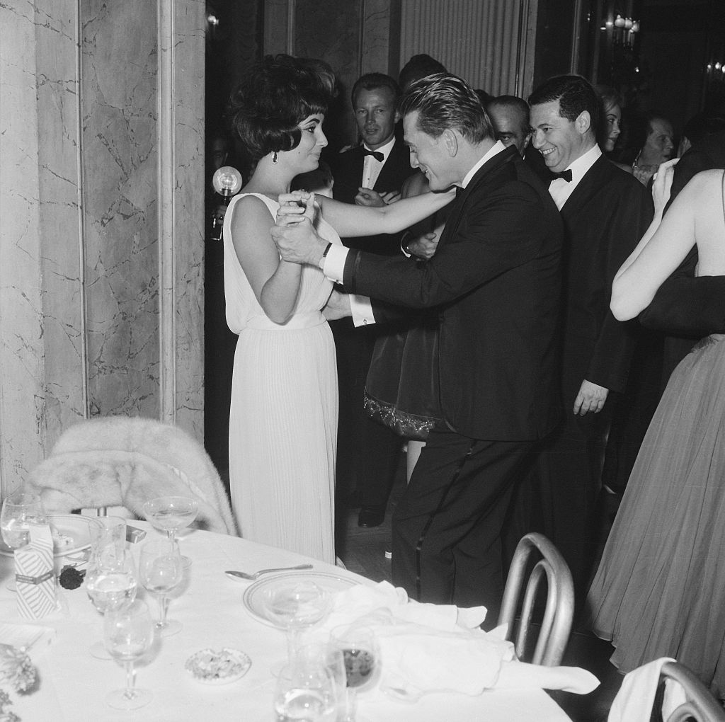 A bordo de um Valentino, Elizabeth Taylor dança com Kirk Douglas em1961: pontapé inicial para careira internacional do estilista italiano