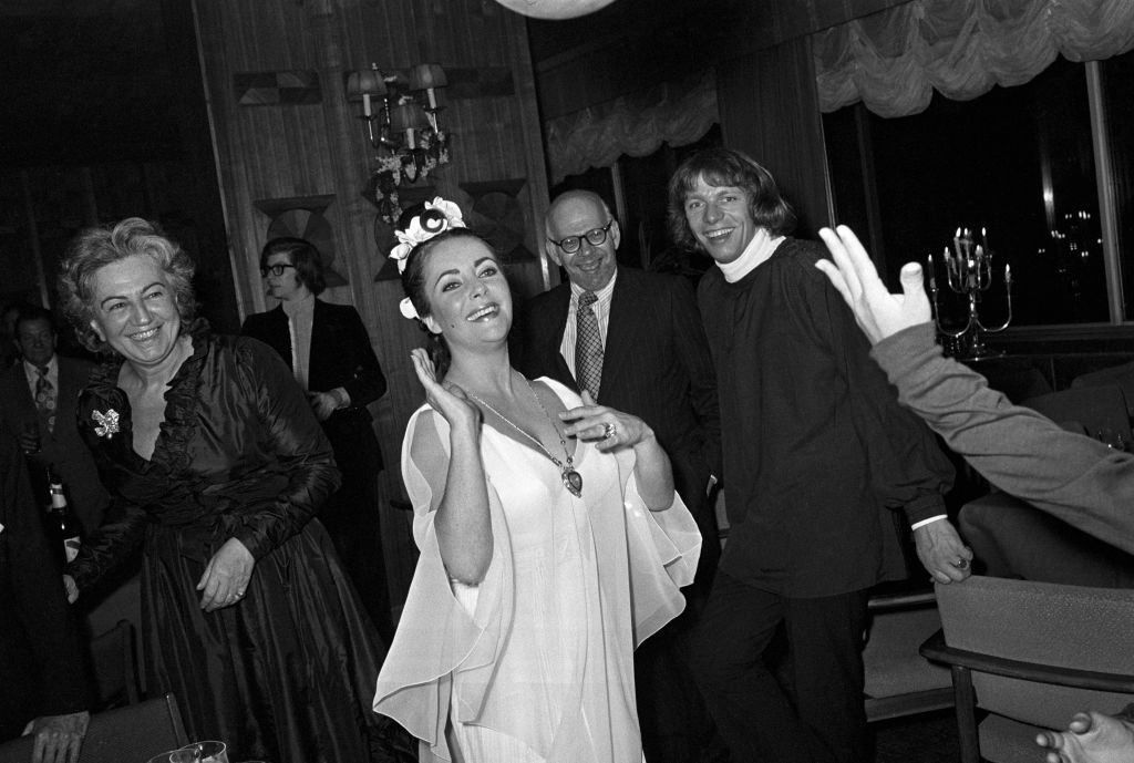 Elizabeth Taylor exibe o colar em formato de coração que ganhou do marido Richard Burton em sua festa de aniversário de 40 anos